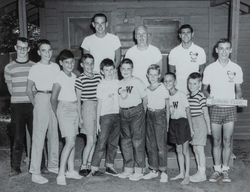 Don as a Camp Counselor Holding a College Sign